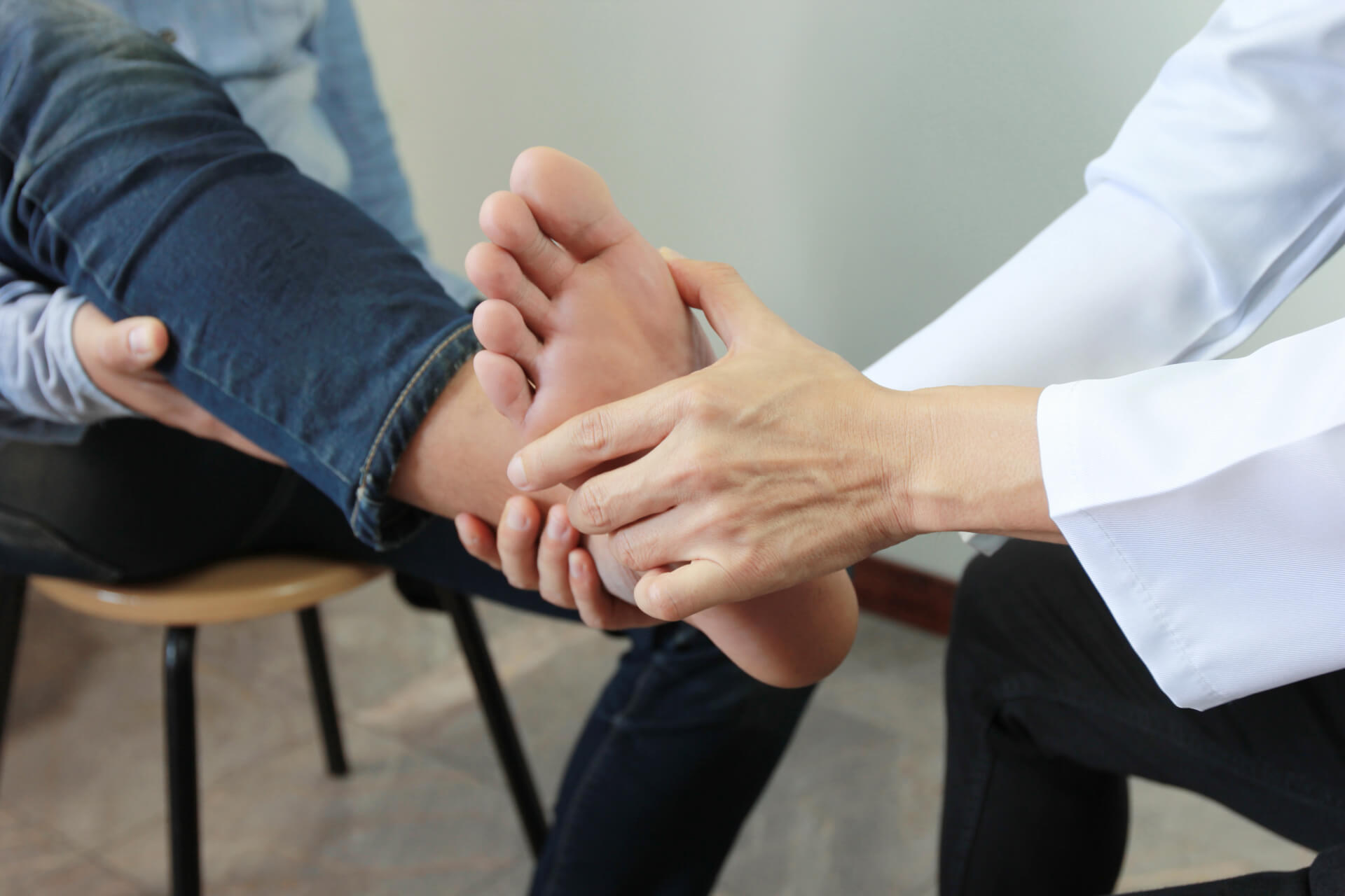 Closeup of Man feeling pain in her foot while the doctor examines.