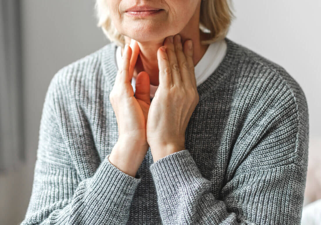 Sick senior adult elderly women touching her neck.