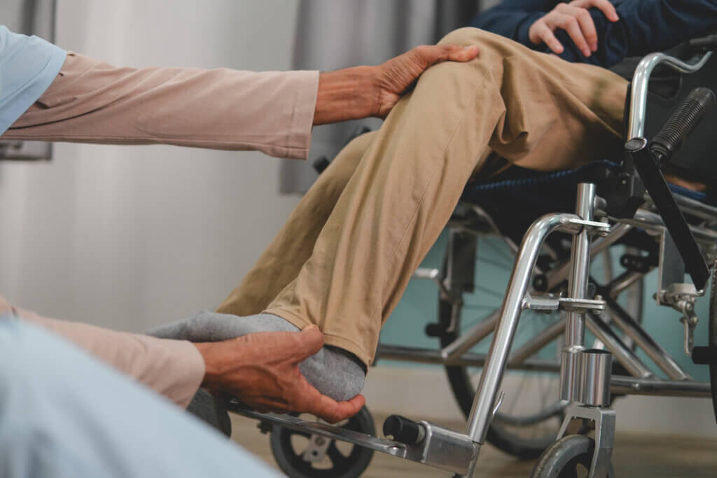 A doctor examining a young man in a wheelchair.