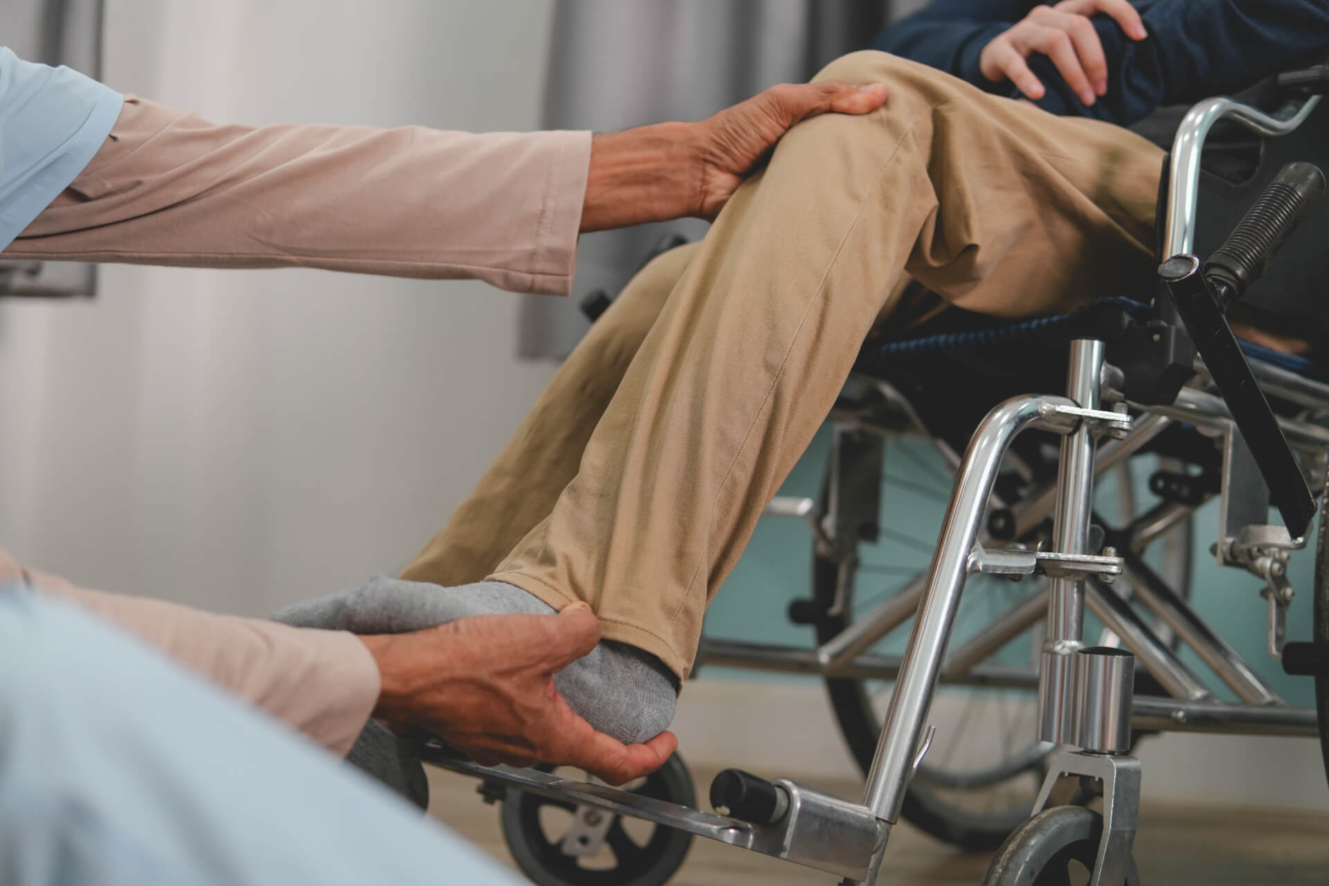 A doctor examining a young man in a wheelchair.