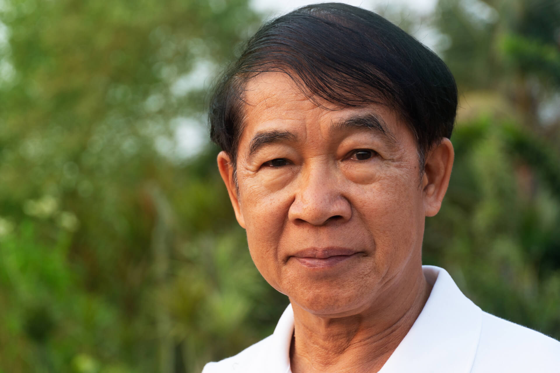 Senior Filipino man outside in nature.