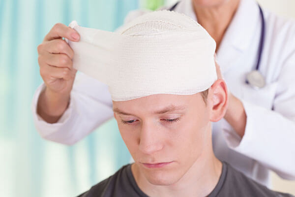 Boy with a head injury being cared for by a physician.