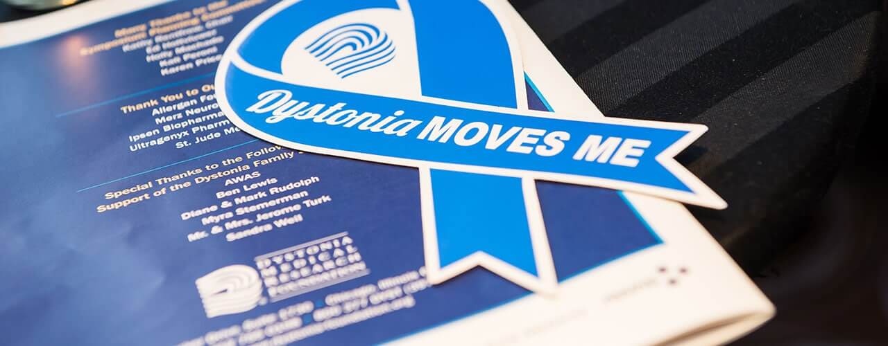Photo of a publication with a "Dystonia Moves Me" ribbon.