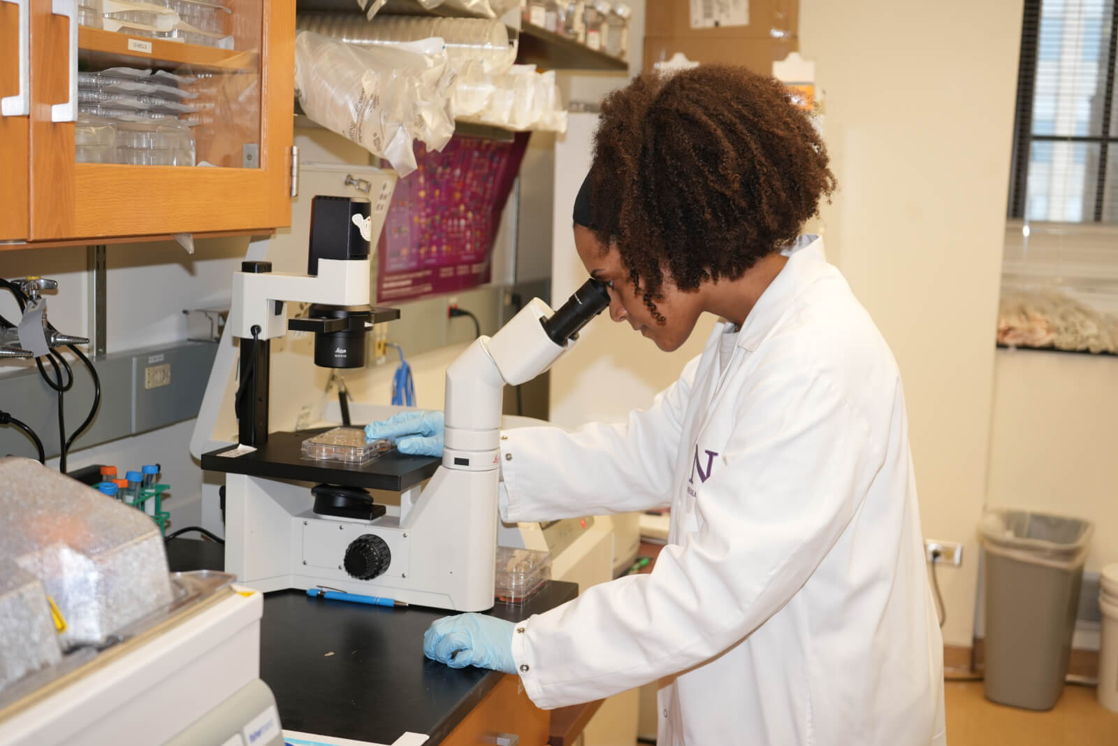 lab technician using microscope